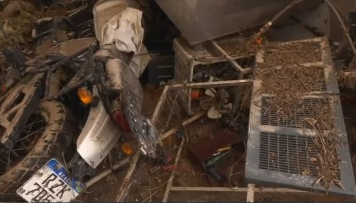 Moto entre os escombros da fábrica de gelo após rompimento de reservatório, em Campina Grande....